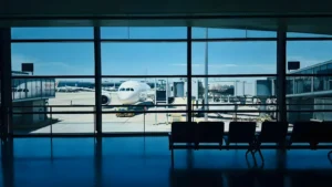 Terminal del aeropuerto con un avión al fondo, detención en el aeropuerto de Alicante-Elche