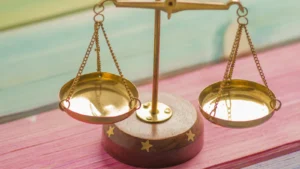 Balanza de la justicia sobre fondo rosa y azul, cambio de sexo y ley de violencia de género